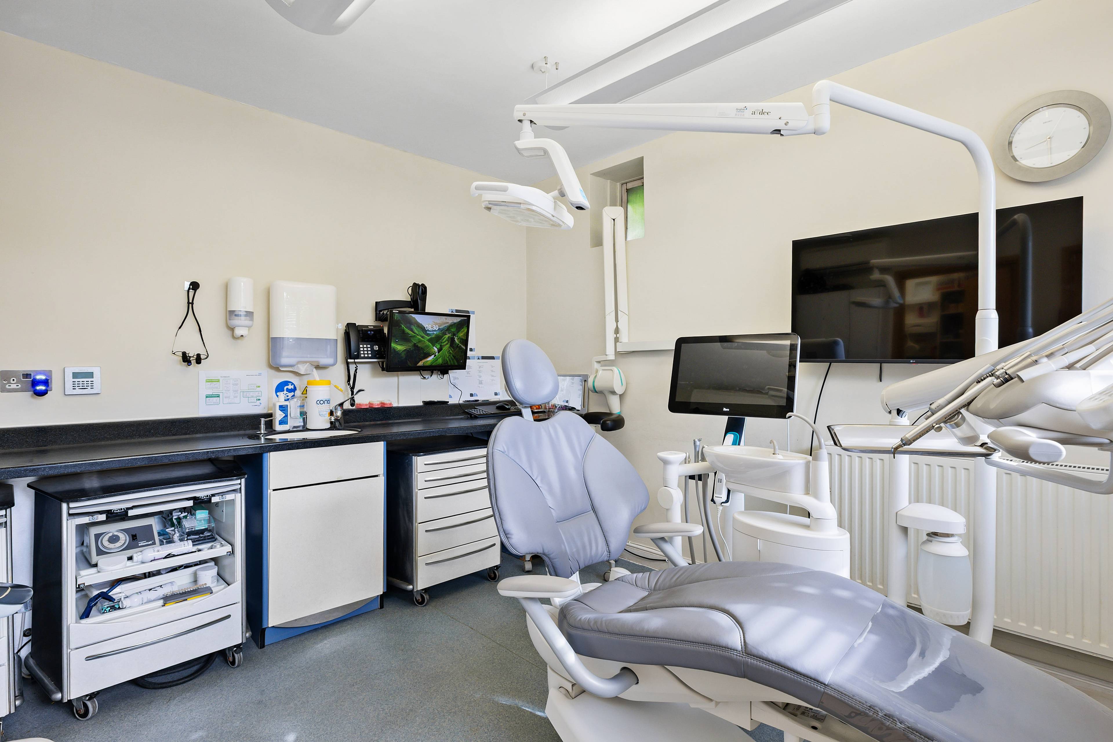 Modern dental treatment room at Bath Spa Dentistry featuring a patient chair, digital imaging screens, and advanced dental equipment.