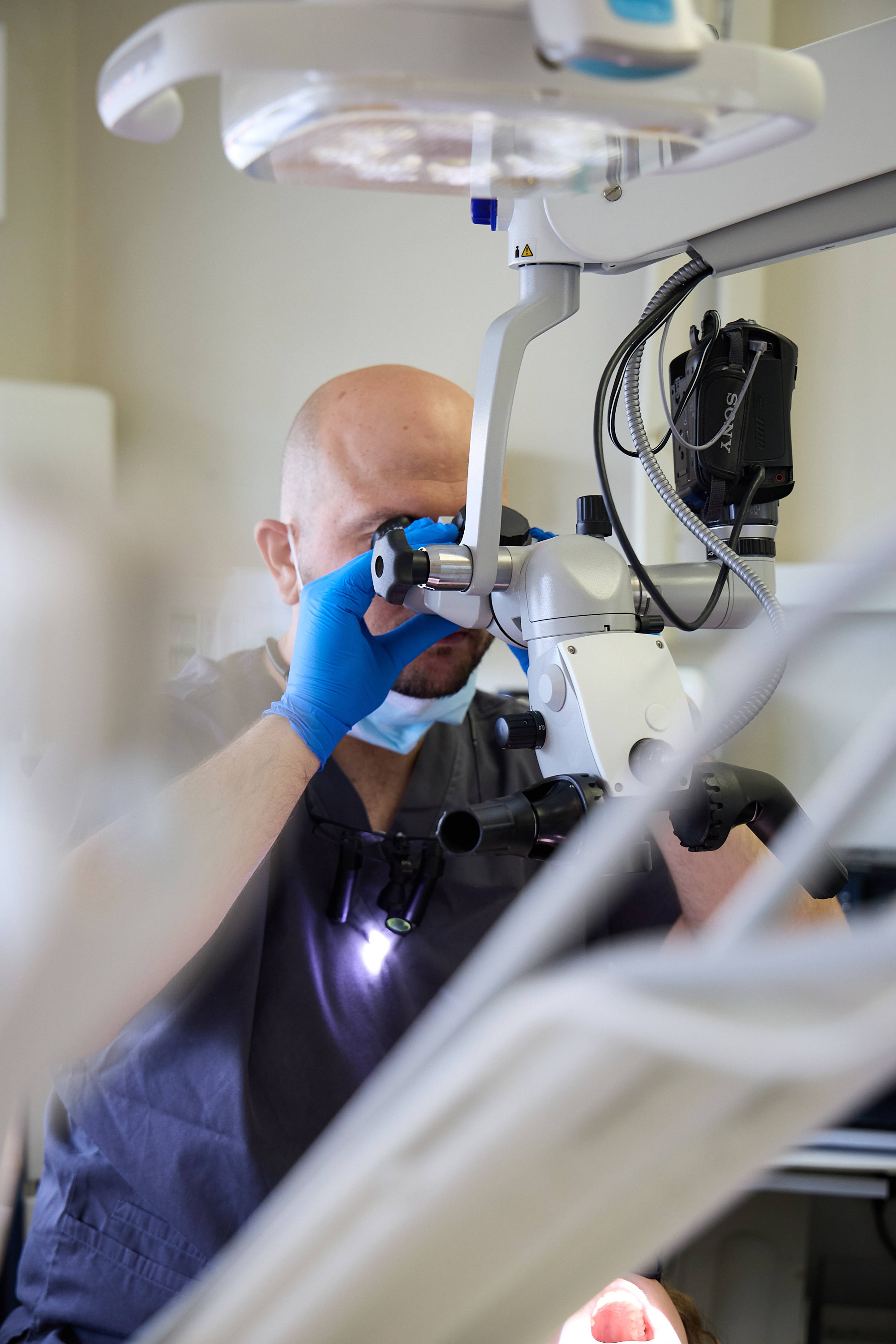 Dental professional using a dental microscope to perform a precise examination and treatment at Bath Spa Dentistry.