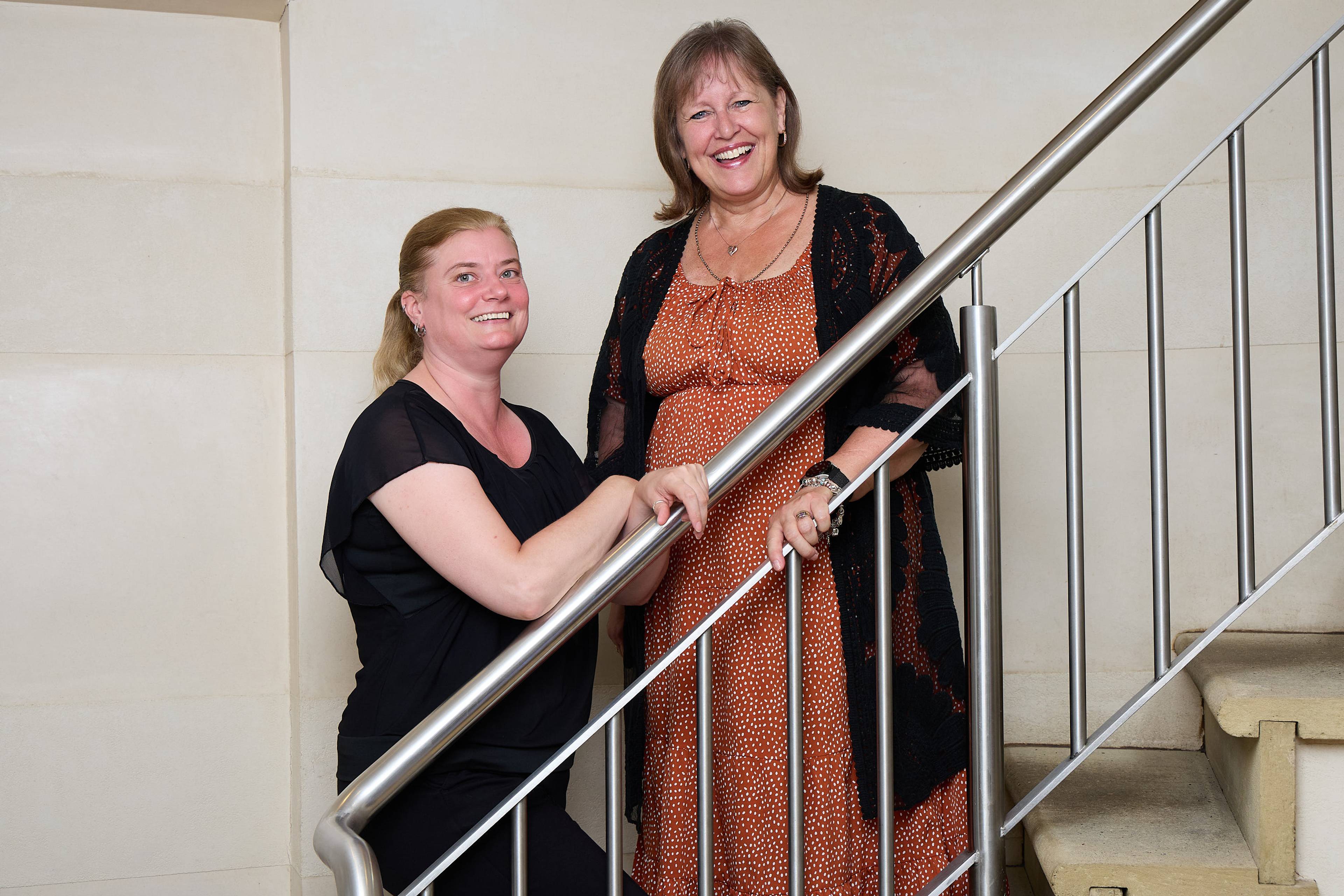 Two members of the Bath Spa Dentistry team standing together on a staircase inside the practice.