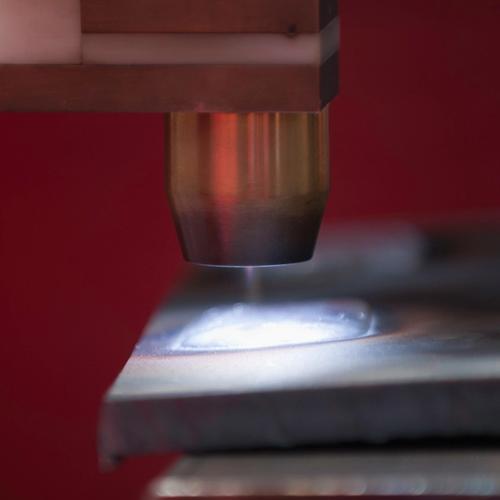 Machine-mounted torch working on a metal joint, labelled plasma welding by the stock contributor.