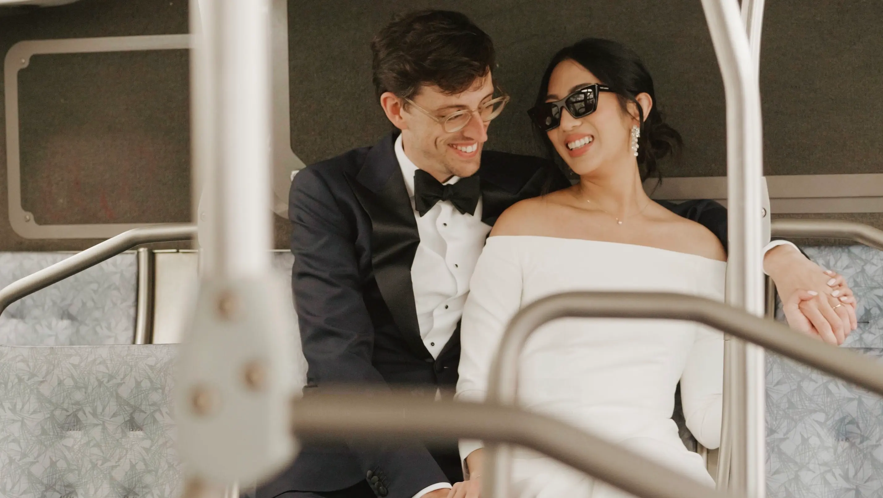 Jeni and John sit close on a city bus smiling