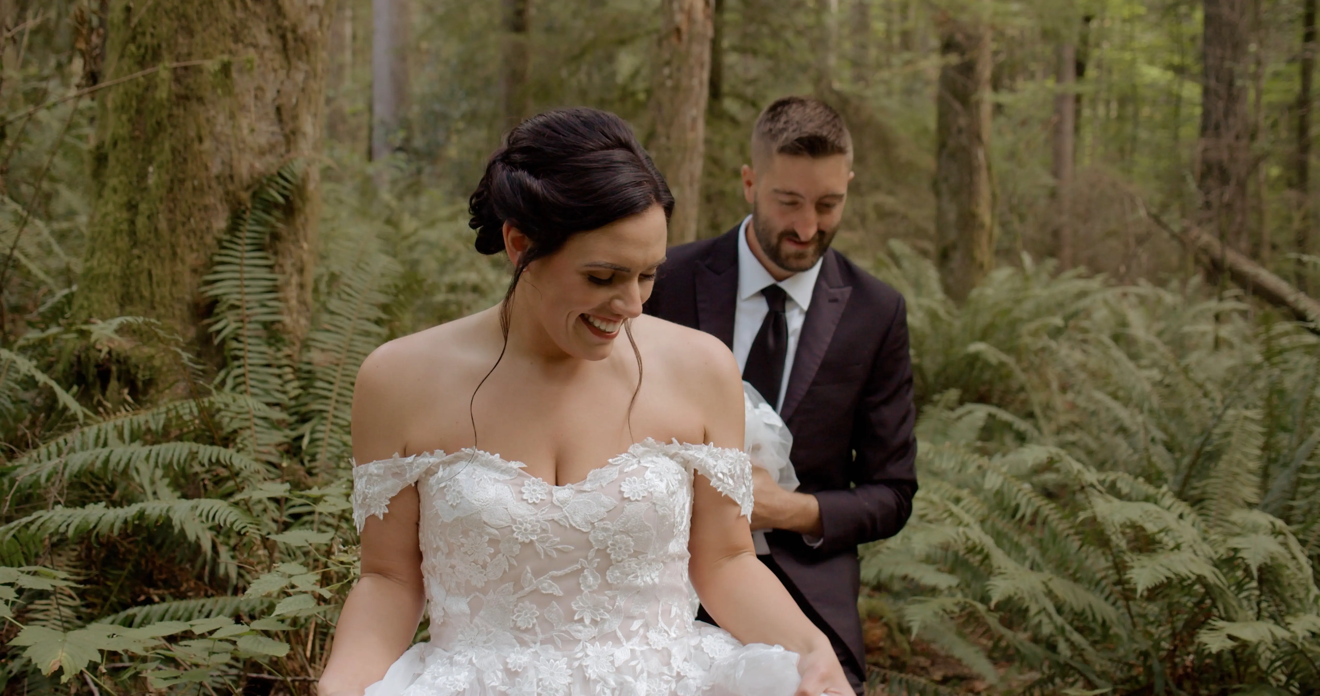 Daniyah stands in a traditional wedding gown and smiles at Sameer