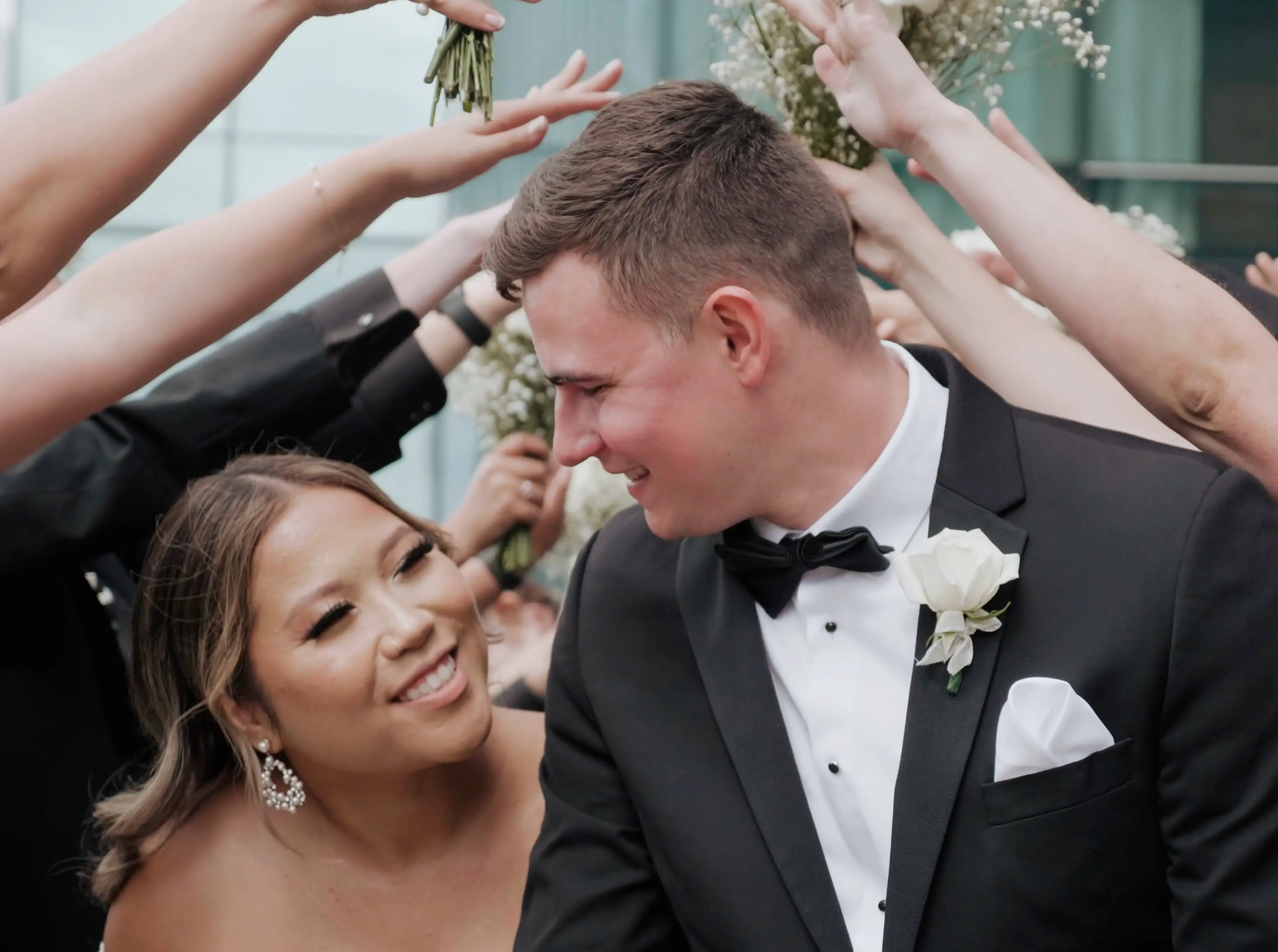 Alyssa and Alex smile at one another as they move through a tunnel under their friends' arms