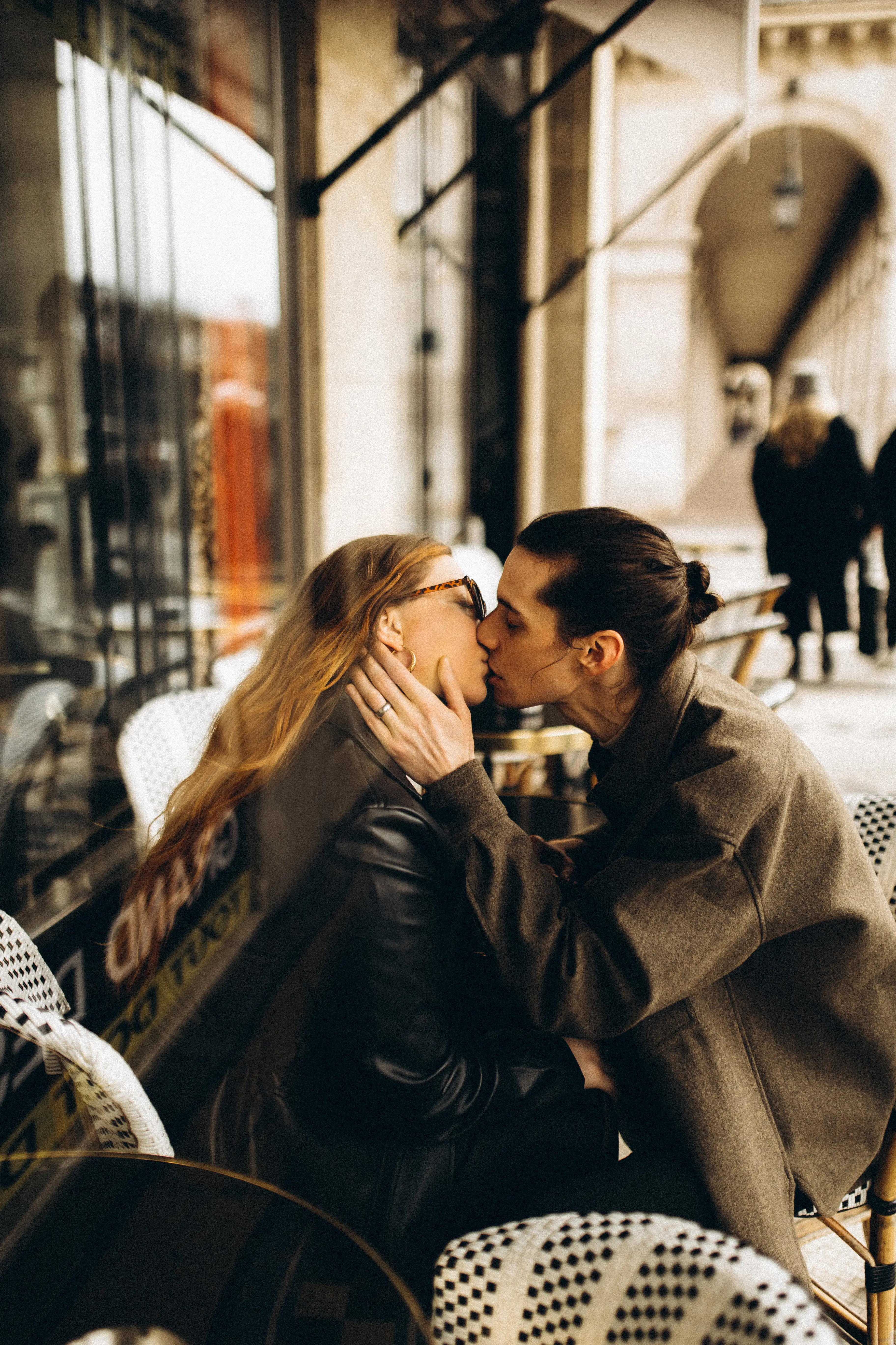 Austin + Emily kissing on a patio in Paris