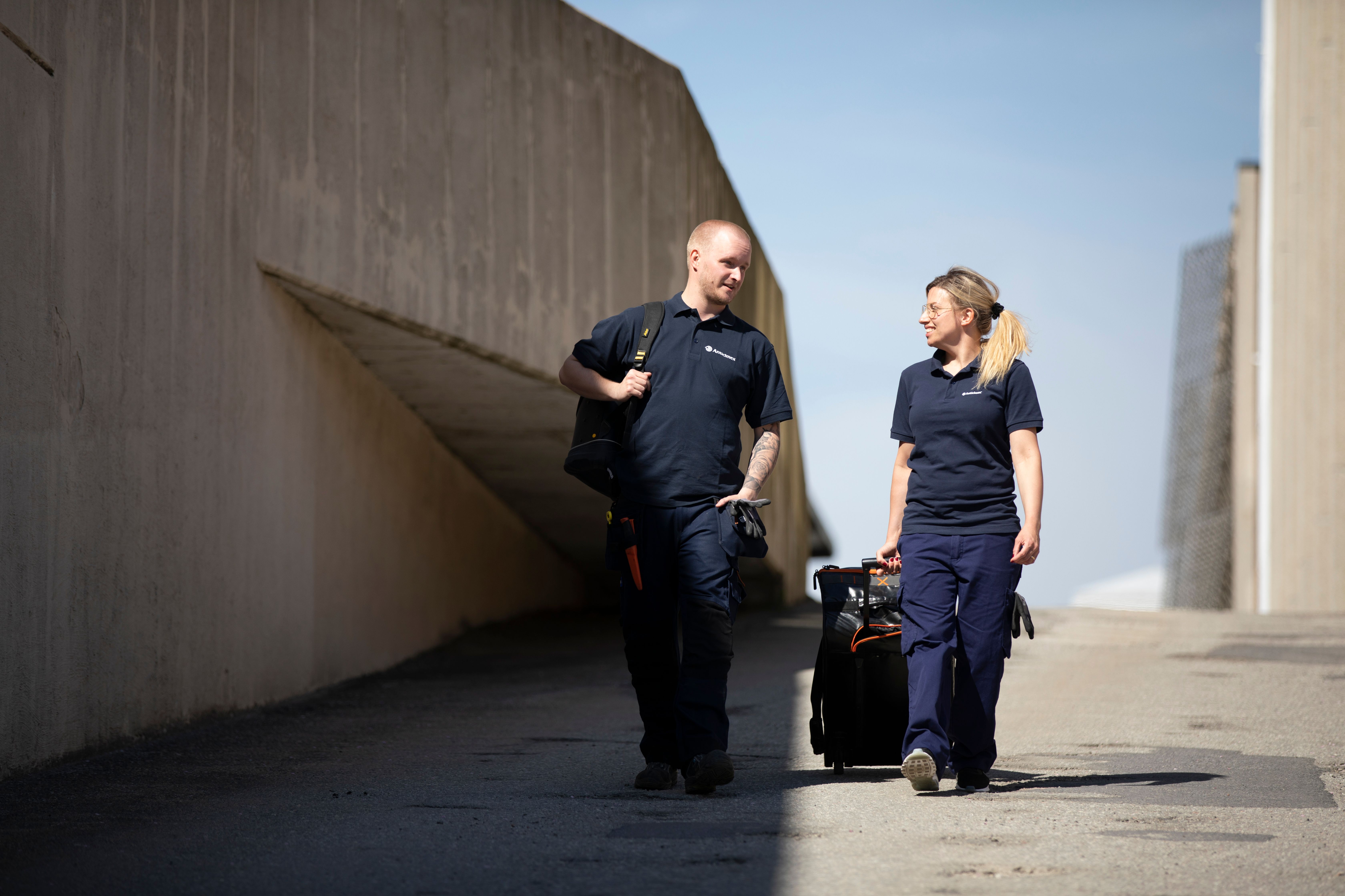 Anticimexin tuholaistorjujat juttelemassa ja kävelemässä