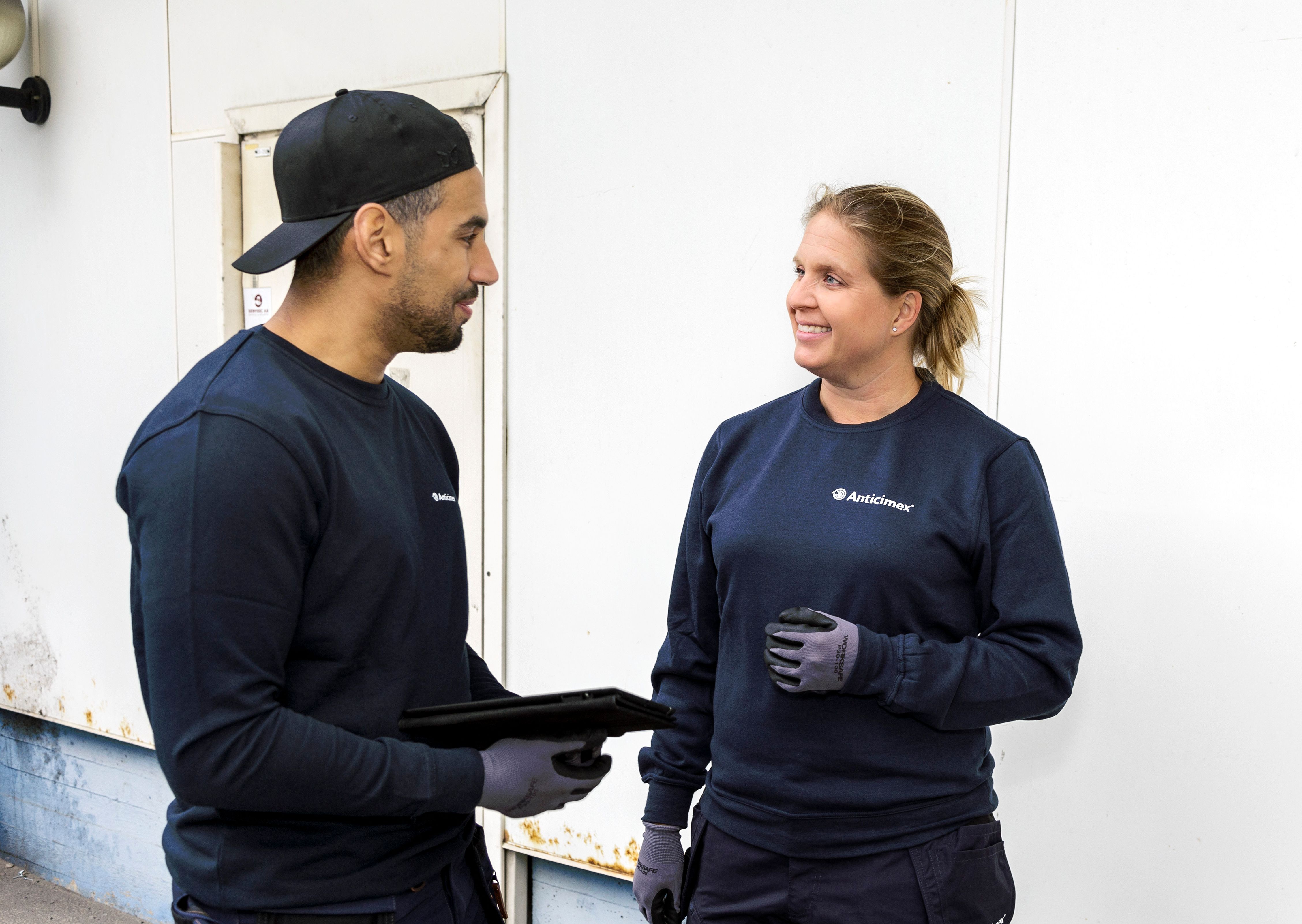 Anticimexin työntekijät katsovat toisiaan hymyillen.