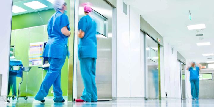 Personnel soignant en tenue médicale circulant dans le couloir d'un établissement de santé.