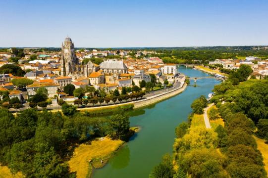 Vue aérienne d'une ville de France traversée par une rivière, dominée par une imposante cathédrale.