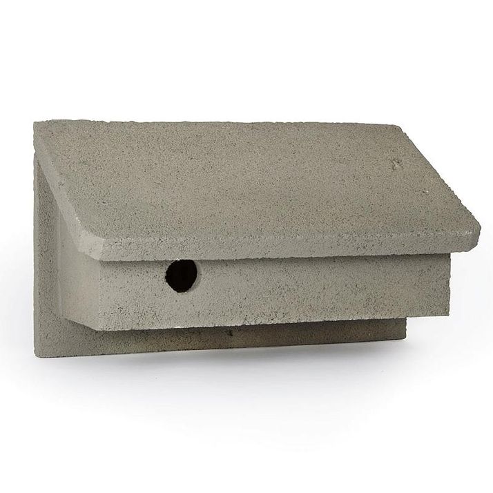 Concrete birdhouse with a sloped roof and a round entrance hole.