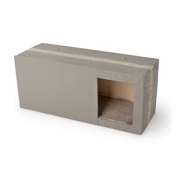 Light gray concrete block with a rectangular opening revealing a tan interior on one end and a smooth panel on the other.