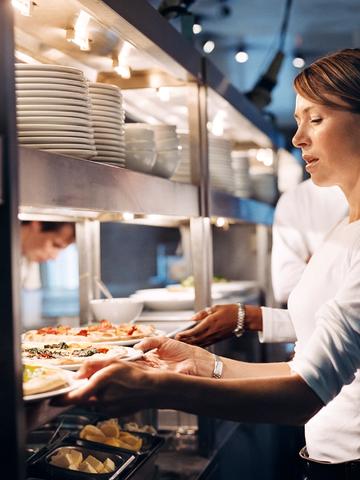 Kvinna ska servera mat till restauranggäster