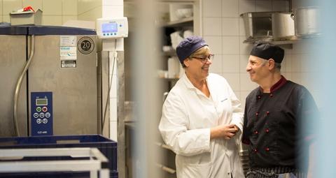 En tekniker från Anticimex och en kund i ett industrikök gör en matsäkerhetsinspektion