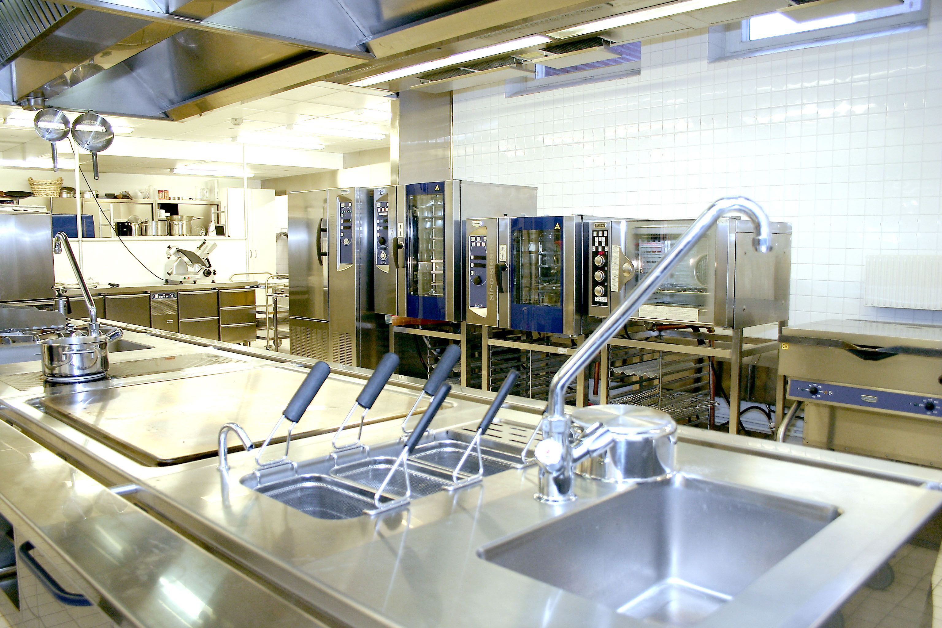 Tomt och rent restaurangkök med bänkar och ugnar där Ansulex släcksystem finns installerat