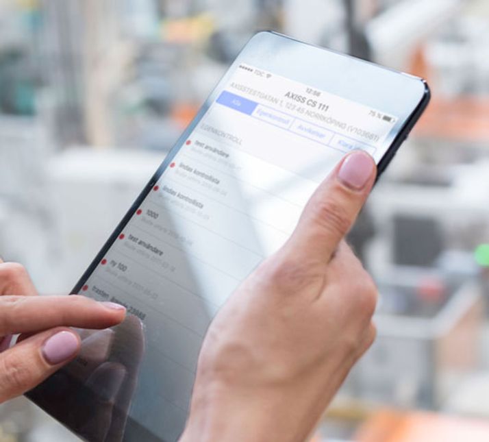 Person håller i surfplatta för digital egenkontroll
