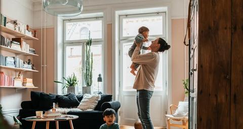 Två kvinnor samtalar om säljansvarsförsäkring i ett gråmålat vardagsrum i bostad