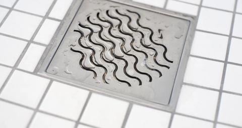 Golvbrunn på klinkergolv och vattendroppar.