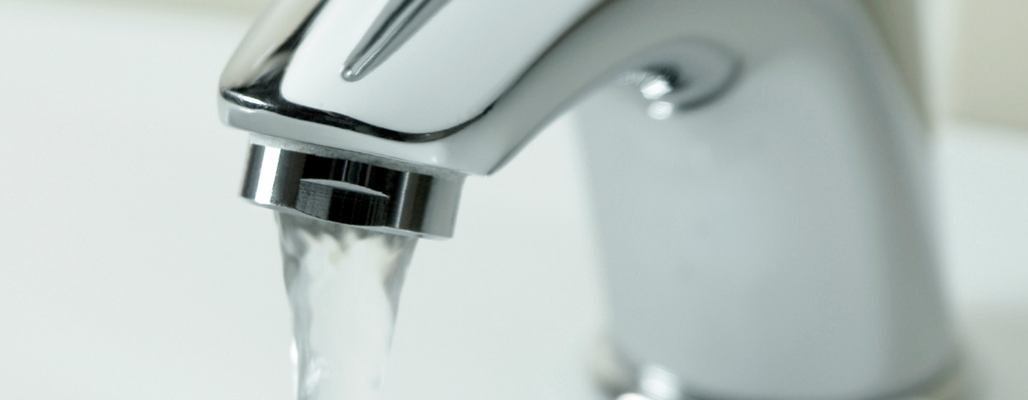 Närbild på vattenkran som spolar vatten