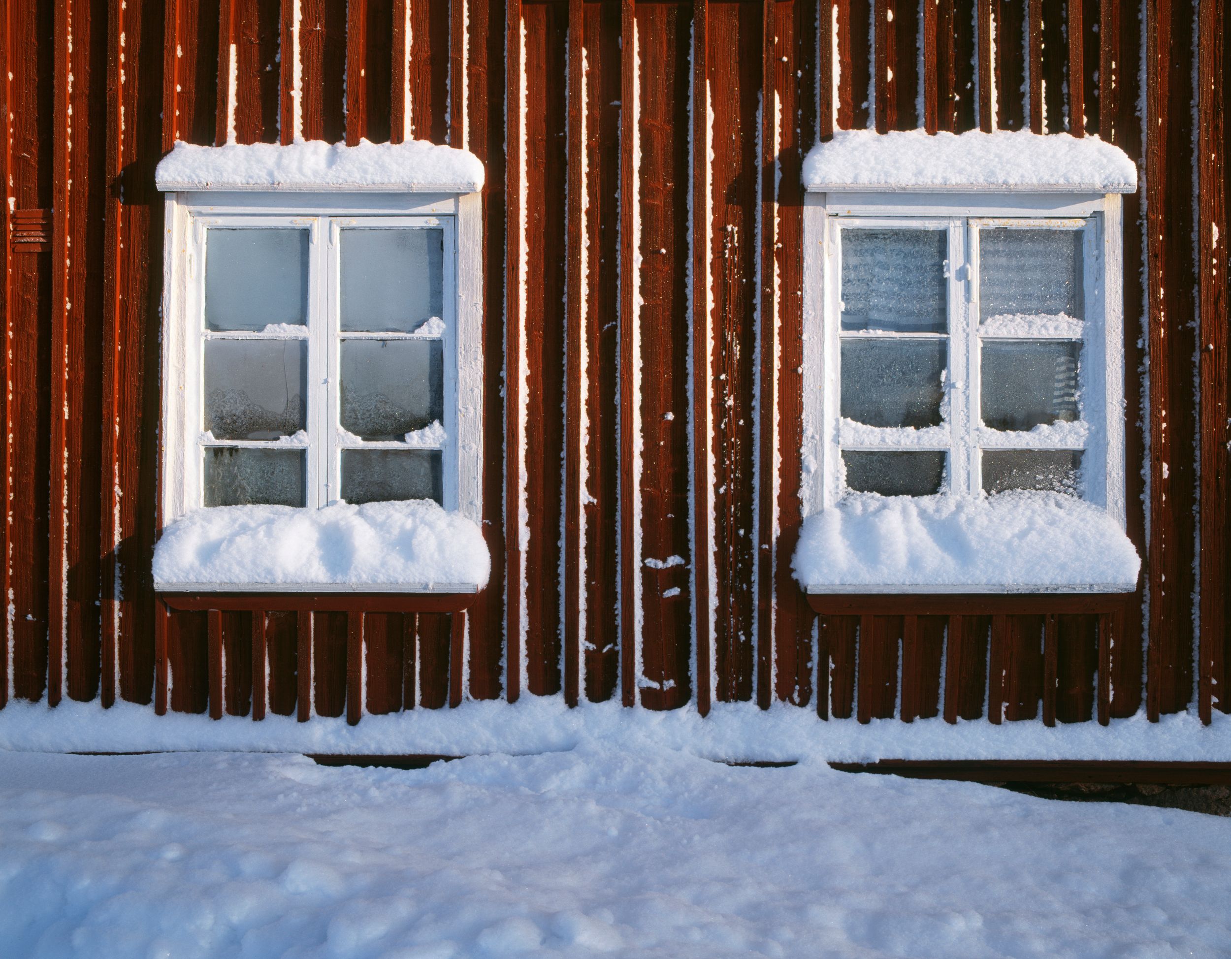 Anticimex Hushälsa - ett vitt hus orange tak och vitt staket i grön trädgård