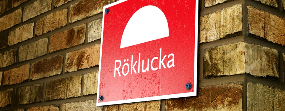Skylt röklucka på tegelvägg