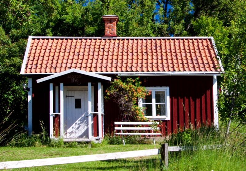 Ett litet rött hus i grönskan