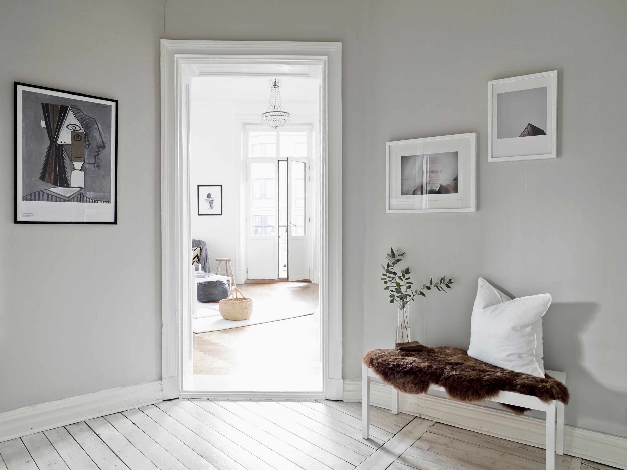 Vitt hus med stor ek i förgrunden längs en kvartersgata