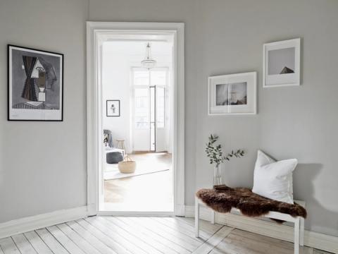 Grå hall med vitt trägolv i bostadsrätt