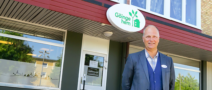 Man utanför byggnad med Göingehemskylt