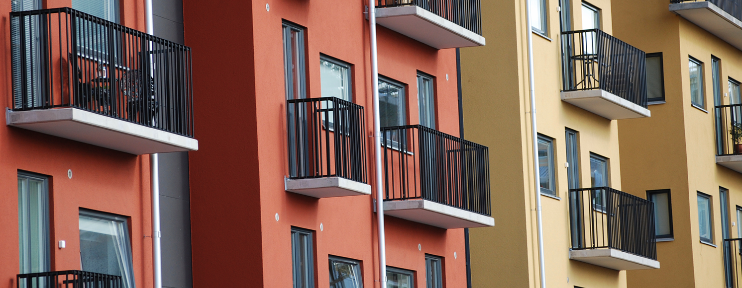 Lägenhetshus i rött och gult med svarta balkonger