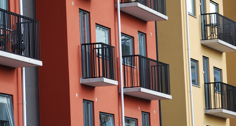Lägenhetshus i rött och gult med svarta balkonger