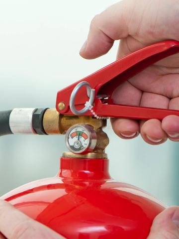 Hand som håller i en handbrandsläckare