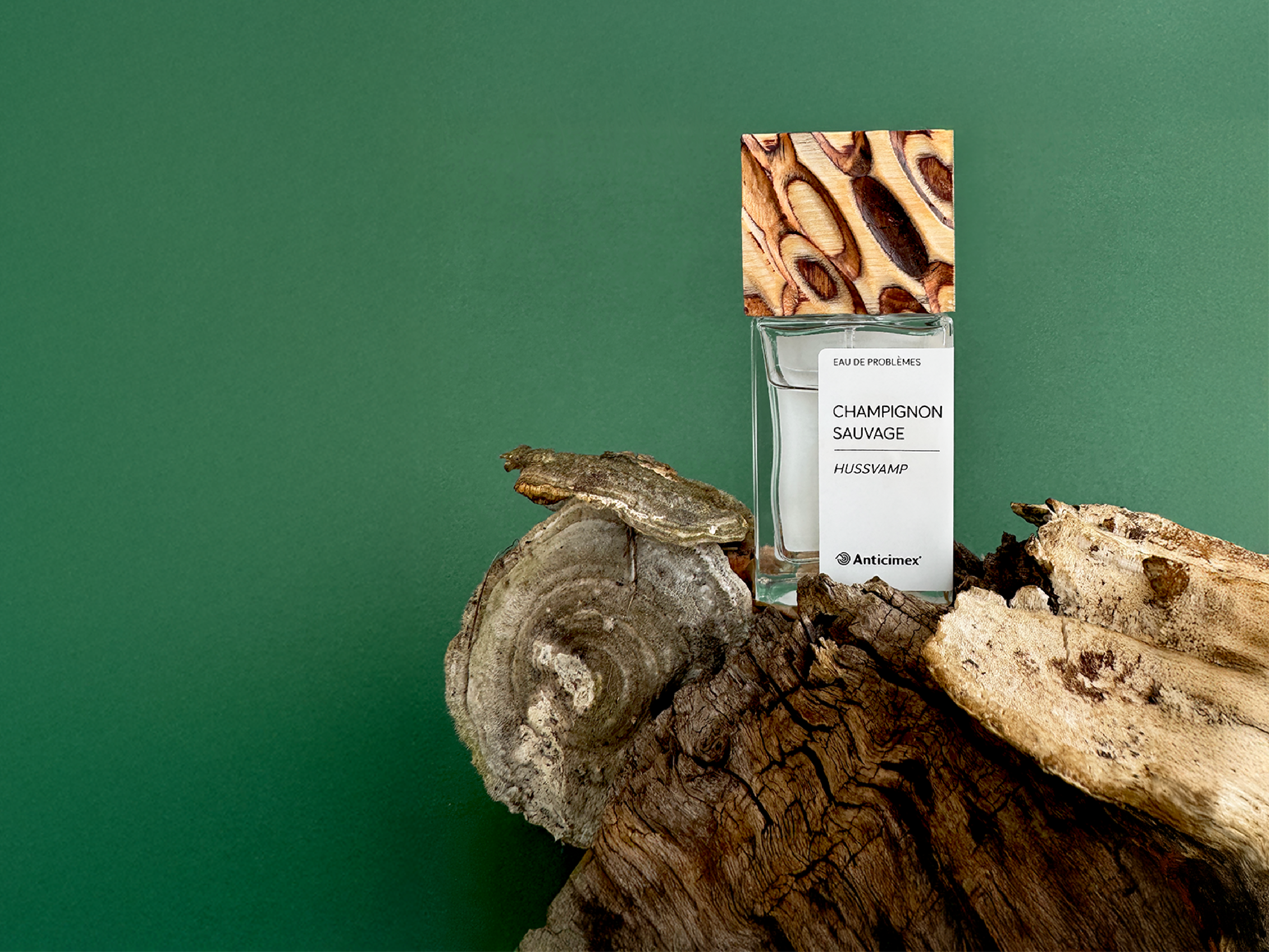 Anticimex parfym - Champignon Sauvage - med doft av husvamp på staplade naturliga material och grön bakgrund
