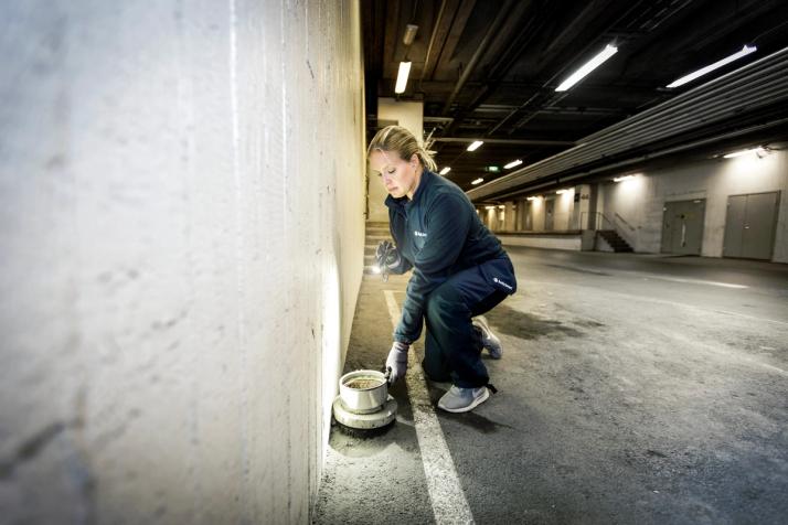 Kvinnlig tekniker från Anticimex undersöker ett rör för att säkerställa att skadedjur inte kan ta sig in i fastigheten