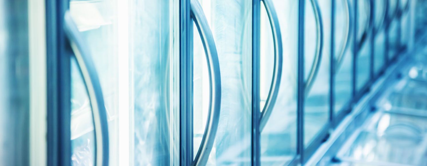 Handtag på stora kylskåp med digital temperaturkontroll uppställda på rad 