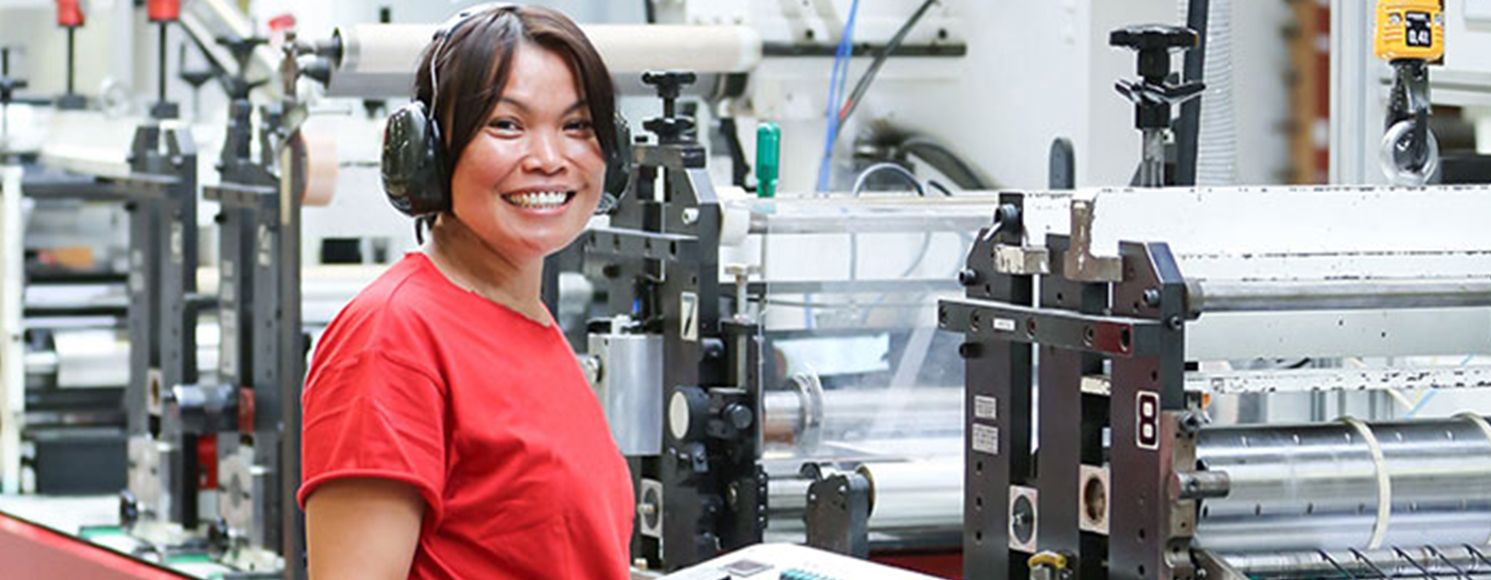 Kvinna som är Anticimex-kund framför maskin i fabrik