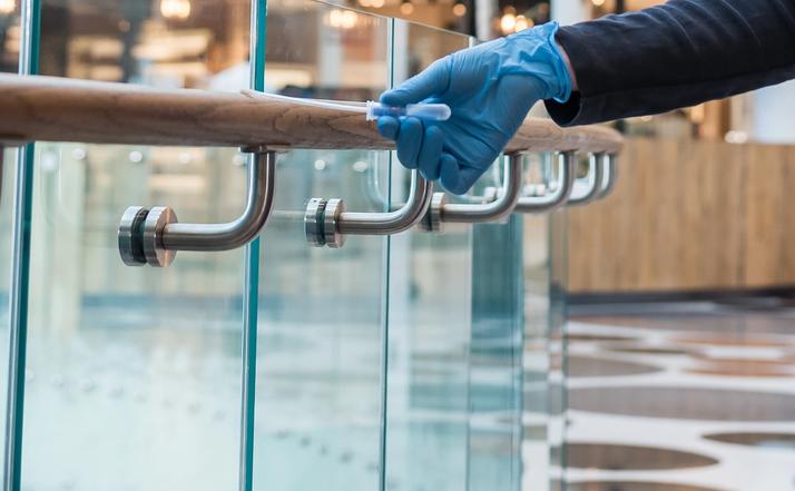 Desinfektion - tekniker utför provtagning på räcke i köpcentrum