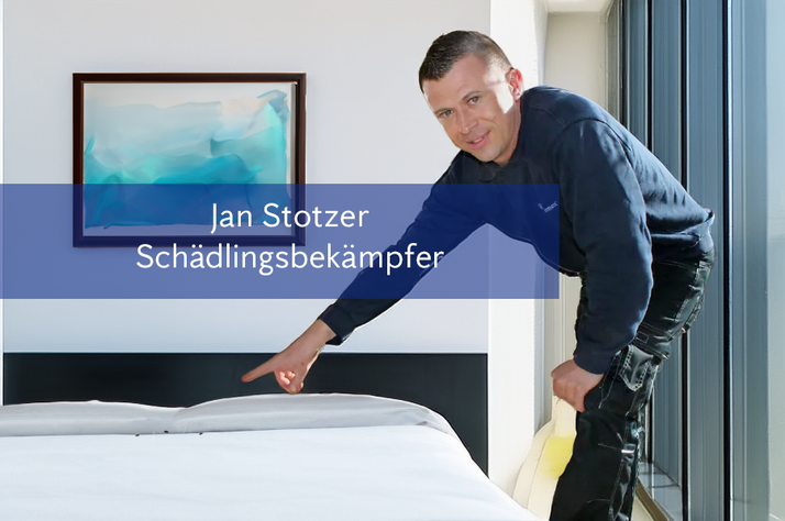 Jan Stotzer, a smiling pest controller, points to a bed.