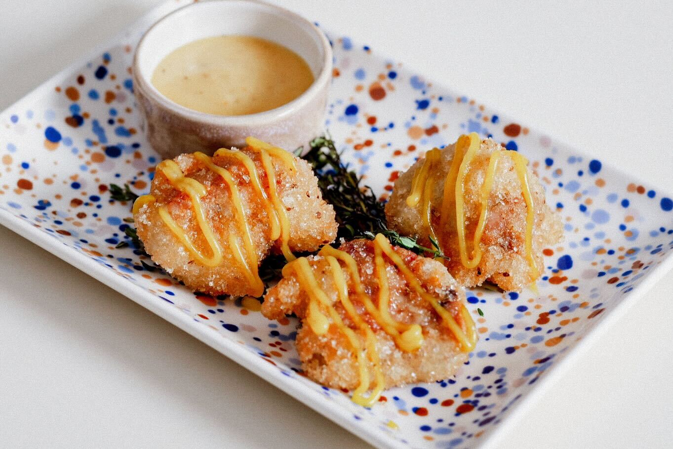 En tallerken med en fritert smårett med dip 