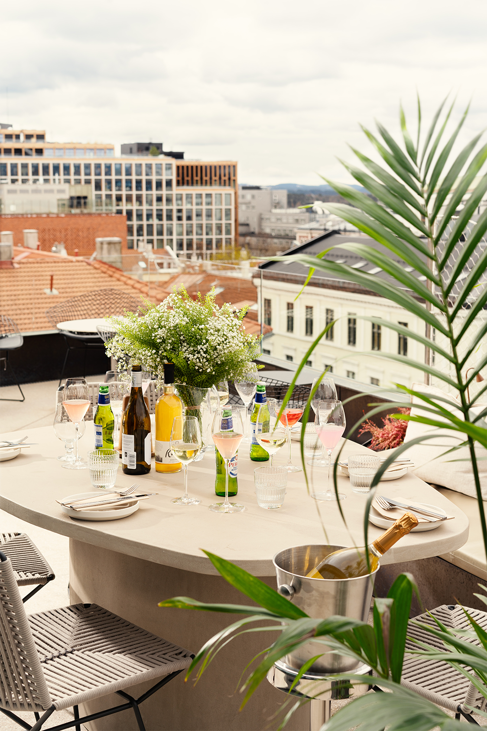 Et pent dekket bord med champagnekjøler på takterrassen en sommerdag