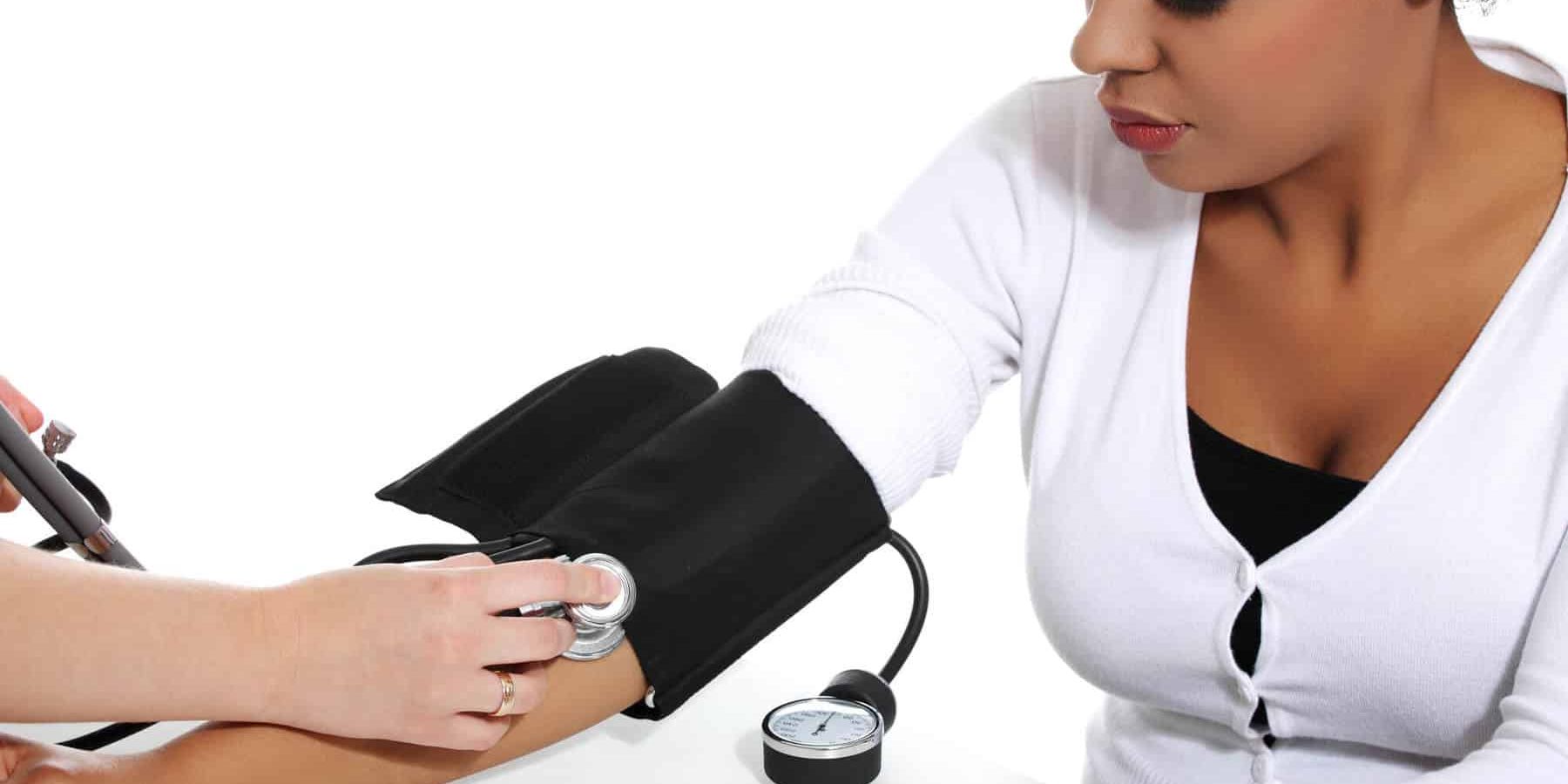 Doctor checking blood pressure of pregnant woman.