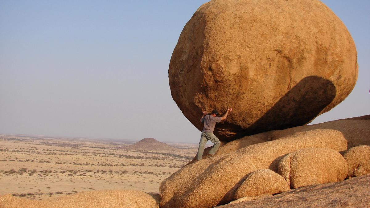 Man leaning forward on a rock
