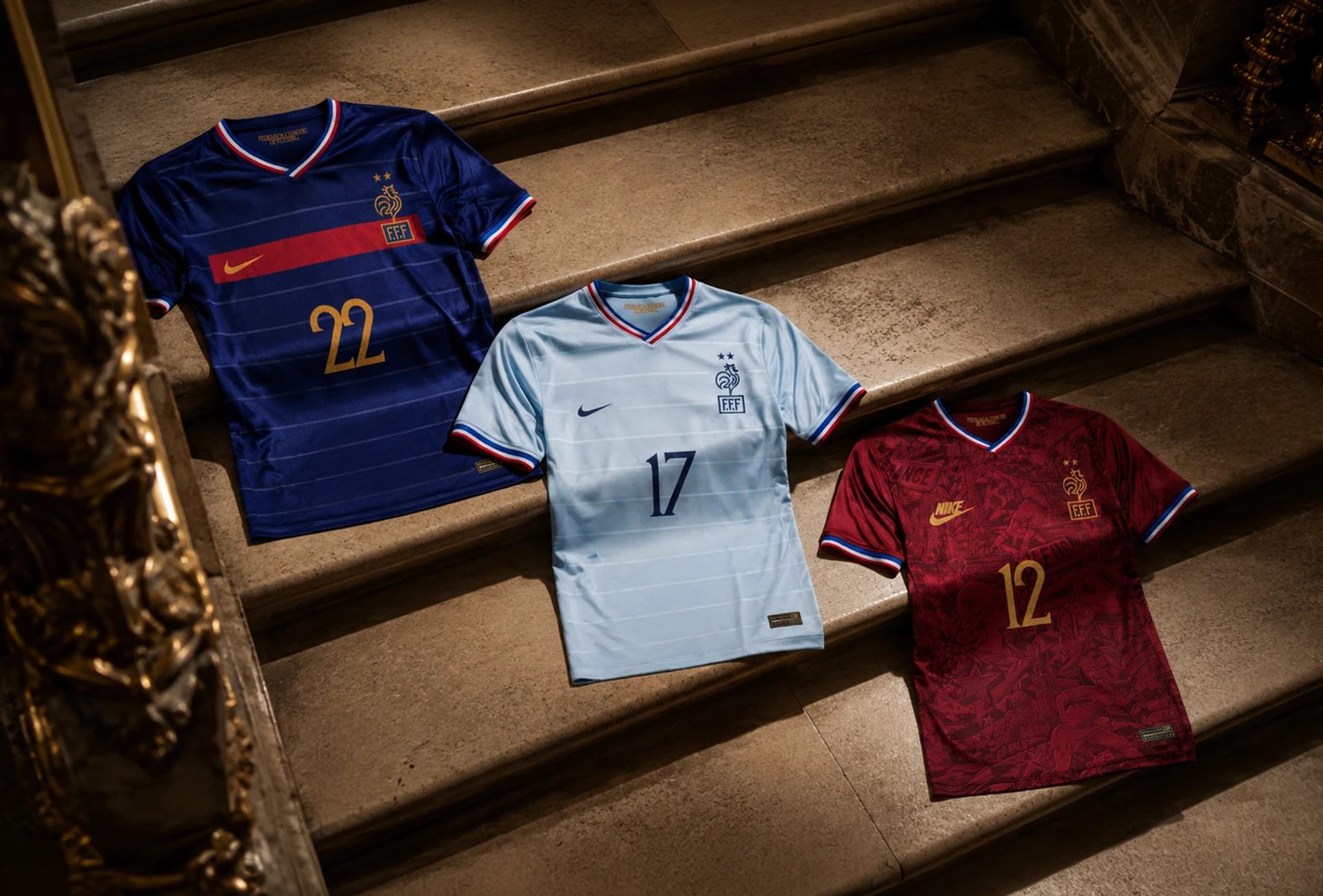 Three FFF Nike football shirts in navy, pale blue and red, numbered 22, 17 and 12, arranged on stone steps.