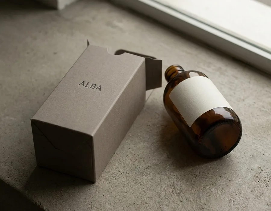 Monolithic single-material packaging in warm neutrals — minimalist luxury objects photographed on cream backdrop