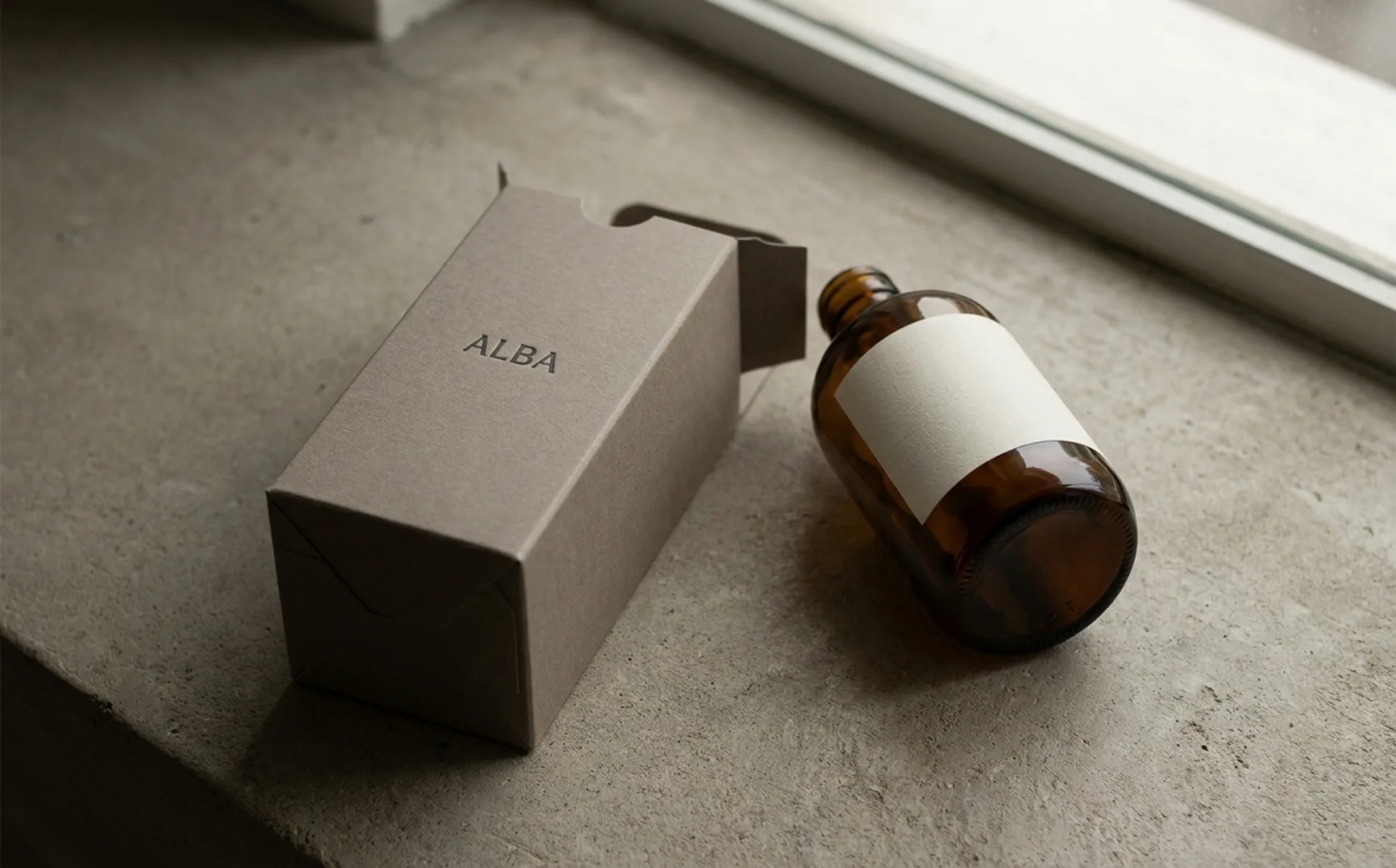 Monolithic single-material packaging in warm neutrals — minimalist luxury objects photographed on cream backdrop
