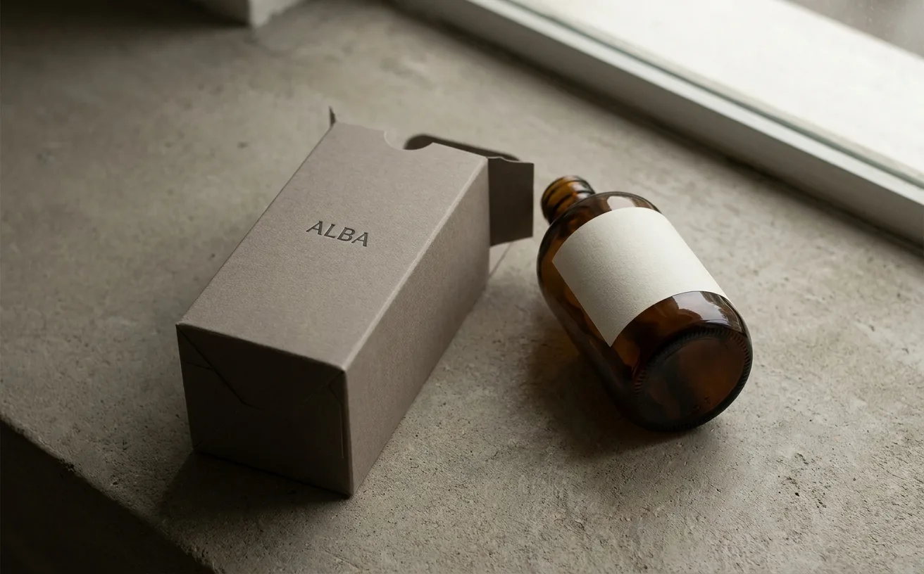 Monolithic single-material packaging in warm neutrals — minimalist luxury objects photographed on cream backdrop