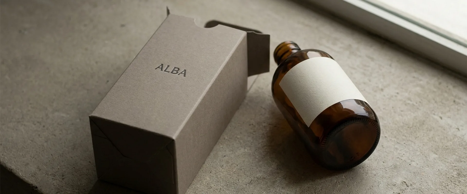 Monolithic single-material packaging in warm neutrals — minimalist luxury objects photographed on cream backdrop