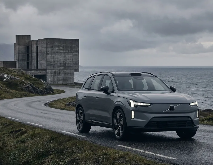 A contemporary Volvo parked on a Scandinavian coastal road with the iconic Thor's Hammer headlights, overcast Nordic light, desaturated palette