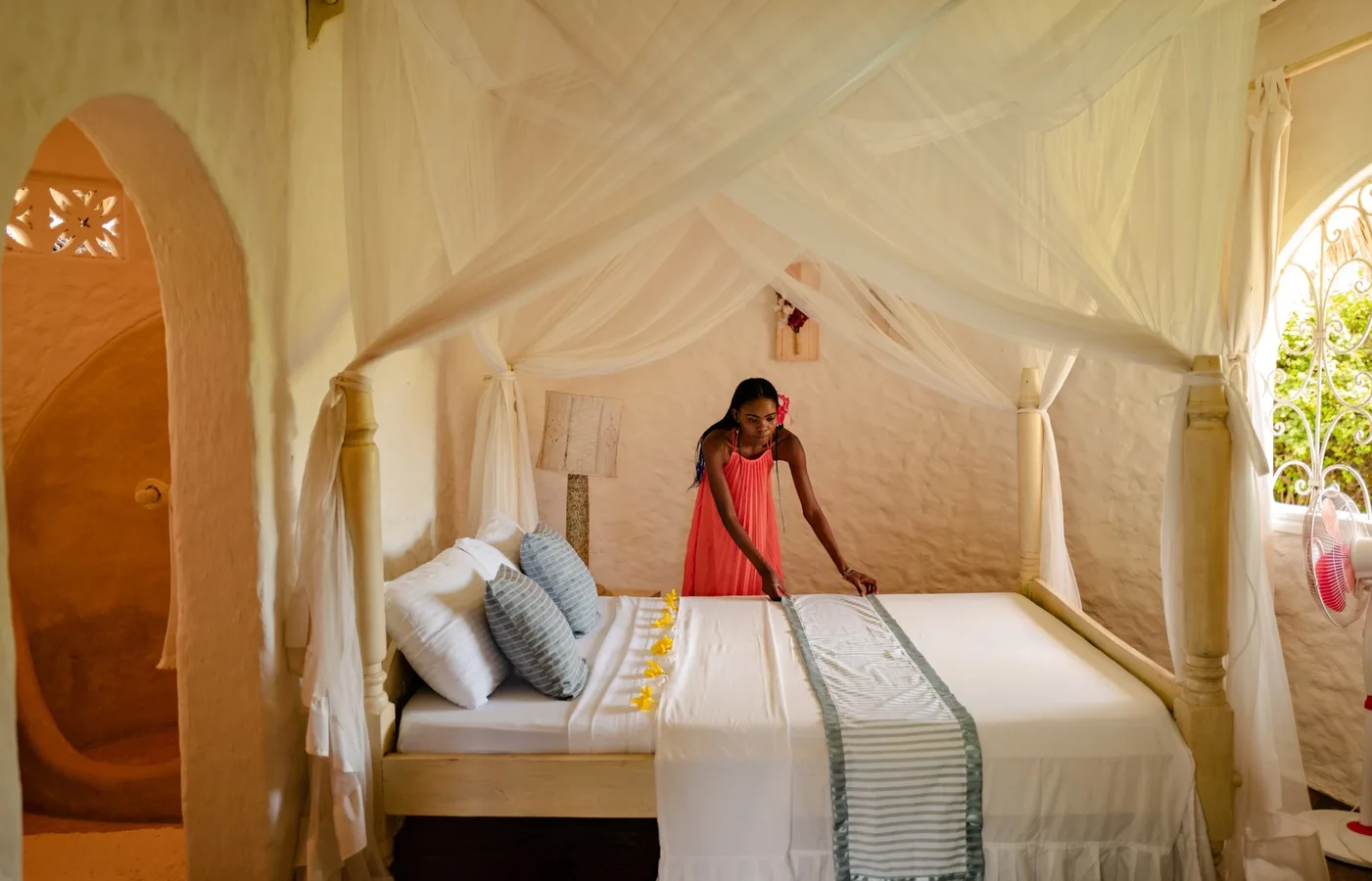 A host preparing a bed inside an Airbnb stay