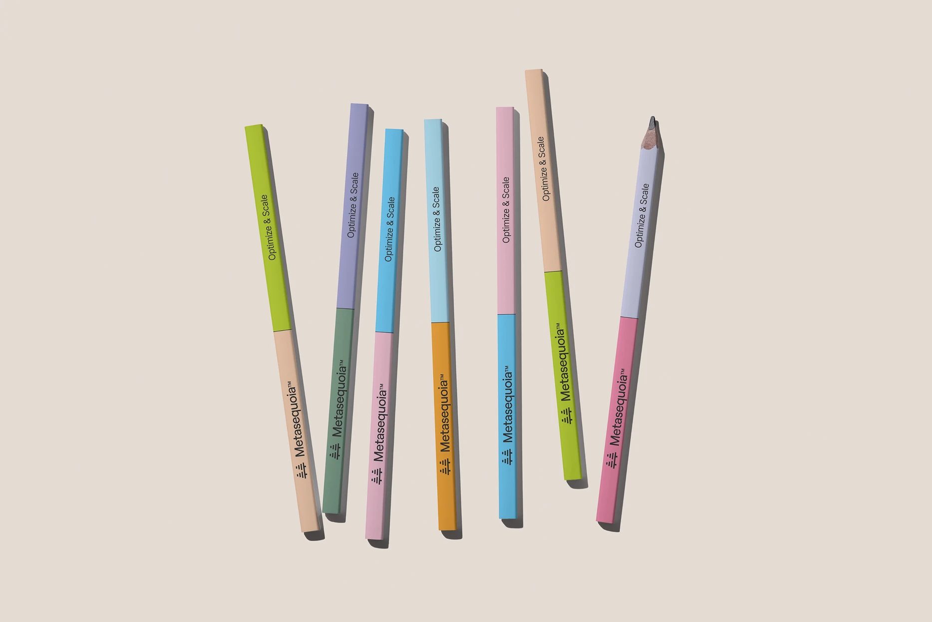 Seven multicoloured pencils printed with “Metasequoia™” and “Optimize & Scale” stand vertically on a beige background.