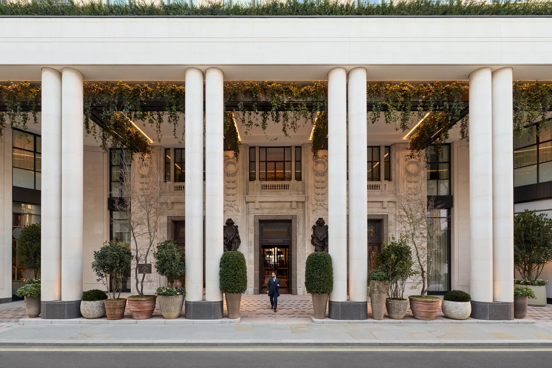 The colonnaded facade of Six Senses London at The Whiteley, planted and open to the street