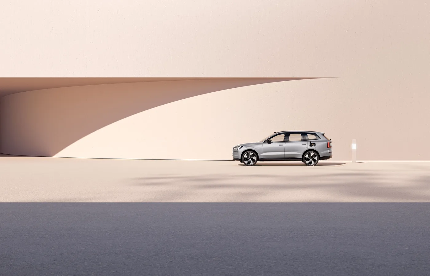 A Volvo EX90 parked in a pale minimal architectural setting